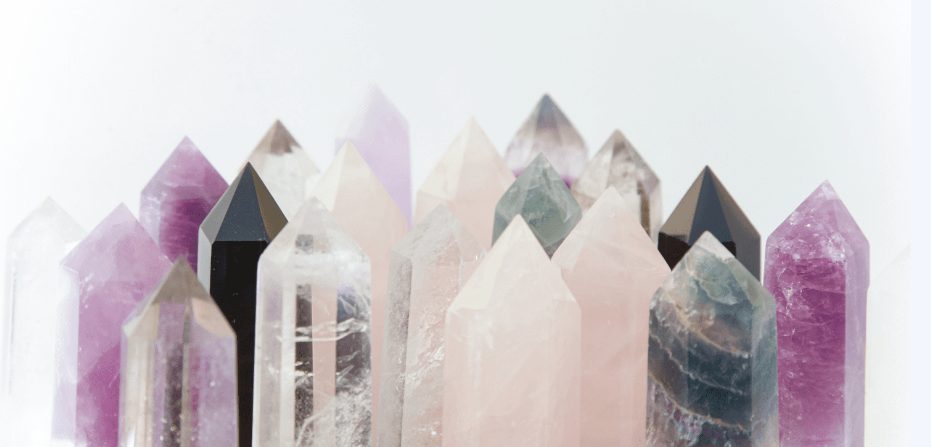A group of polished crystal points in assorted colors including pink, purple, green, black, and clear.